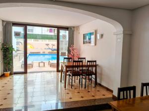 a dining room with a table and chairs and a pool at Hostal Horizonte in San Antonio