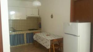 a kitchen with a table and a white refrigerator at Case Vacanze Tropea La Pinnata in Tropea