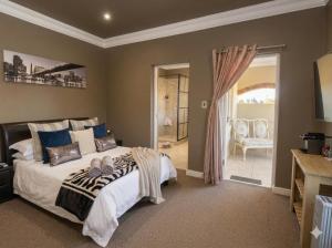 a bedroom with a large bed and a door to a patio at Sandmartins Private Secure Villa in Simondium +36 photos