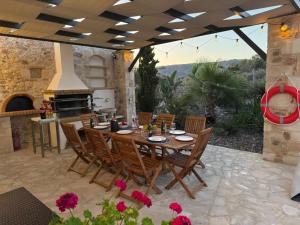 a patio with a table and chairs and a fireplace at MayaElisa Villa with Heated Pool, By Hellocrete in Vamos