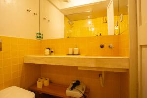 a bathroom with a sink and a toilet and a mirror at Estúdio 24 na Boavista, JAMBA House in Porto +27 photos