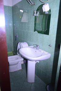 ein Bad mit einem Waschbecken und einem WC in der Unterkunft Hotel Deja in Tirana