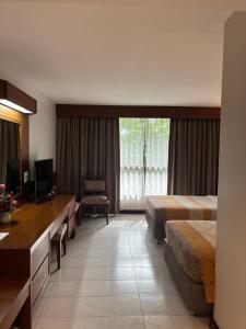 a hotel room with two beds and a television at โรงแรมฉัตรแก้ว in Ban Dan Chang