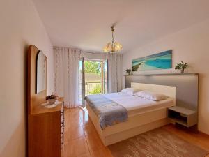 a bedroom with a bed and a window at Apartments Nevenka K. in Čižići