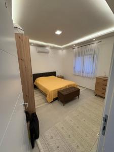 a bedroom with a bed with a yellow bedspread at Villa Sunset in Donji Štoj