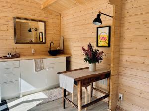 a kitchen with a table and a sink in a cabin at Haapsi Hideaway Garden Cabin in Haapsi