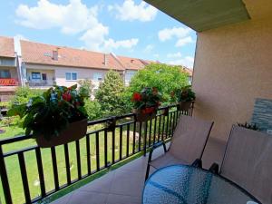 a balcony with a table and chairs and flowers on a fence at Stan na dan Ilicka in Brčko