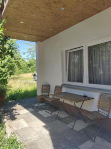 two chairs and a picnic table on a porch at Gästehaus Café Daheim - Self Check-in in Buoch