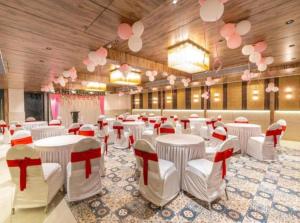 a banquet hall with white tables and red and white chairs at Hotel Luxury Villa - Near IGI Airport Mahipalpur New Delhi in New Delhi