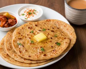 a plate of chapati with a pat of butter and dips at Hotel Radha Rani Bhawan in Vrindāvan
