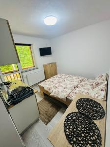 a small room with a bed and a table at Pensiunea NikoBella Panzió in Sovata +23 photos