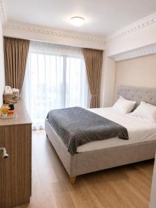 a bedroom with a bed and a large window at WRW Airport Residence in Otopeni