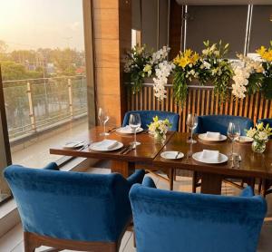 a dining room with a wooden table and blue chairs at Crystal Park Hotel And Restaurant in Lalru +10 photos