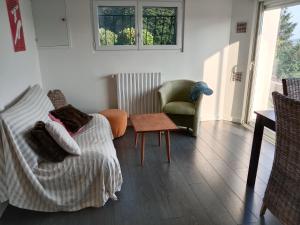 a living room with a couch and a chair at argagnon 64 chambre sbd wc salon privés in Argagnon