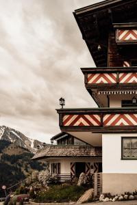 a building on a hill with mountains in the background at Berghotel Zugspitzblick in Zöblen