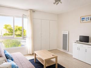 a living room with a couch and a table at Studio - Pleine Mer - 1 avenue des Pays de Monts - 1-1 in Saint-Jean-de-Monts