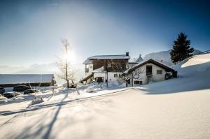 a snow covered street in front of a house at Berghotel Zugspitzblick in Zöblen