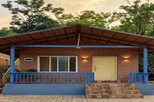 a house with a wooden roof and a porch at Hills View Stay in Māvingundi