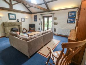 a living room with a couch and a fireplace at Swallow Cottage in Helston