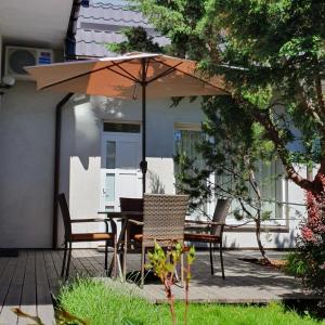 a table and chairs under an umbrella on a patio at Vila Domino in Palanga +30 photos