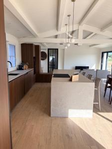 a kitchen and living room with a table and chairs at Doudou House in Saint-Denis-dʼOléron