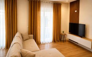 a living room with a couch and a flat screen tv at Sunset Terrace in Durrës