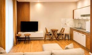 a living room with a tv and a kitchen at Sunset Terrace in Durrës