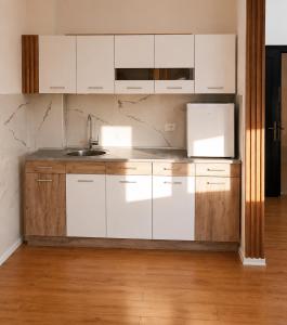 a kitchen with white cabinets and a sink at Sunset Terrace in Durrës +8 photos