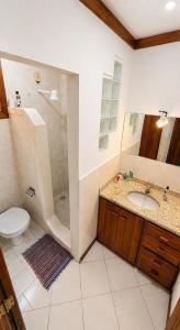 a bathroom with a shower and a sink and a toilet at Nossa Casa Itacaré in Itacaré