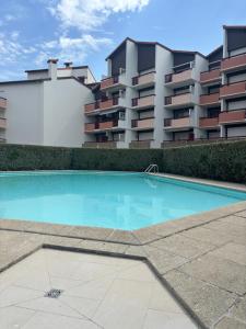 an empty swimming pool in front of a building at Appartement - Bonamour in Capbreton