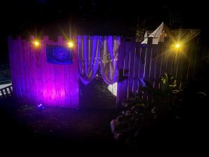 a house with purple lights on a fence at night at La Clef des Ondes in Magescq