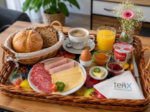 a basket of breakfast foods and drinks on a table at Apartment tenX Mittweida in Mittweida