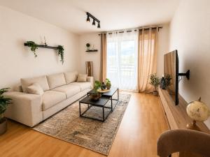 a living room with a white couch and a table at City Lodge Leipzig in Leipzig