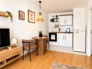 a kitchen and living room with a table and a refrigerator at City Lodge Leipzig in Leipzig