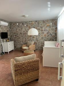 a living room with wicker chairs and a couch at Apartmani Maksan in Pakoštane
