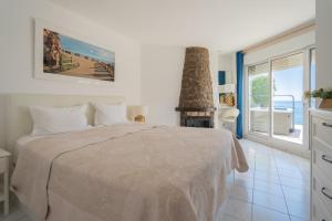 a white bedroom with a bed and a fireplace at Maryvilla Inspiración y Vacaciones - Villa Mascarat in Calpe
