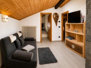 a living room with a couch and a flat screen tv at Mansarda Ossana in Fucine