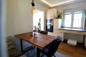 a kitchen with a wooden table and a dining room at Lenz Stay - Ganzes Ferienhaus mit privatem Garten in Kaisersberg