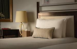 a bedroom with a bed with a pillow and a lamp at Corinthia St George's Bay in St. Julianʼs