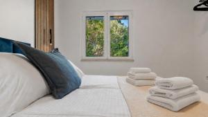 a bedroom with a white bed with towels on it at Villa Aquiterra Bobovisca in Bobovišća