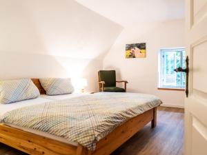 ein Schlafzimmer mit einem Bett und einem Stuhl in der Unterkunft Thielsenhof in Dollerup