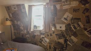 a bedroom with a wall covered in pictures and papers at The Ocean Guest House in Weymouth +152 photos