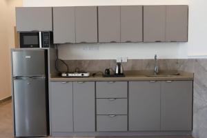 a kitchen with white cabinets and a stainless steel refrigerator at شاليهات تايم in Khamis Mushayt