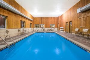 a swimming pool with blue water in a building at Days Inn by Wyndham Evansdale Waterloo in Evansdale