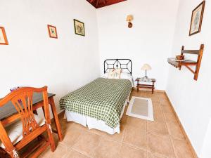 a bedroom with a bed and a wooden chair at Rincón de Mercedes in Fuencaliente de la Palma