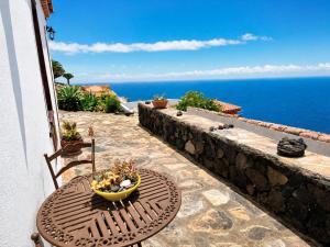 a table and chair on a patio with a view of the ocean at Rincón de Mercedes in Fuencaliente de la Palma