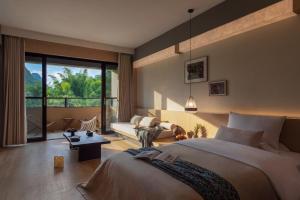 a bedroom with a large bed and a living room at L'Eau Vive de Qixi Meidi - Riverfront Infinity Pool & Log Cabin Cafe - Outdoor Cooking Class - Complimentary Shuttle within 8 Kilometers in Yangshuo +194 photos