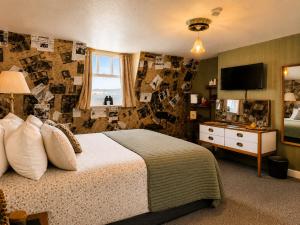 a bedroom with a large bed and a television at The Ocean Guest House in Weymouth