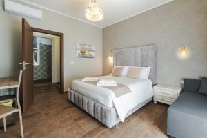 a bedroom with a bed and a desk and a couch at Trieste Centro Rooms-camere eleganti in pieno centro in Trieste +26 photos