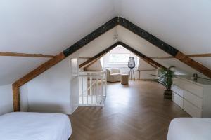 a attic room with a bed and a chair at Oase in Bergen